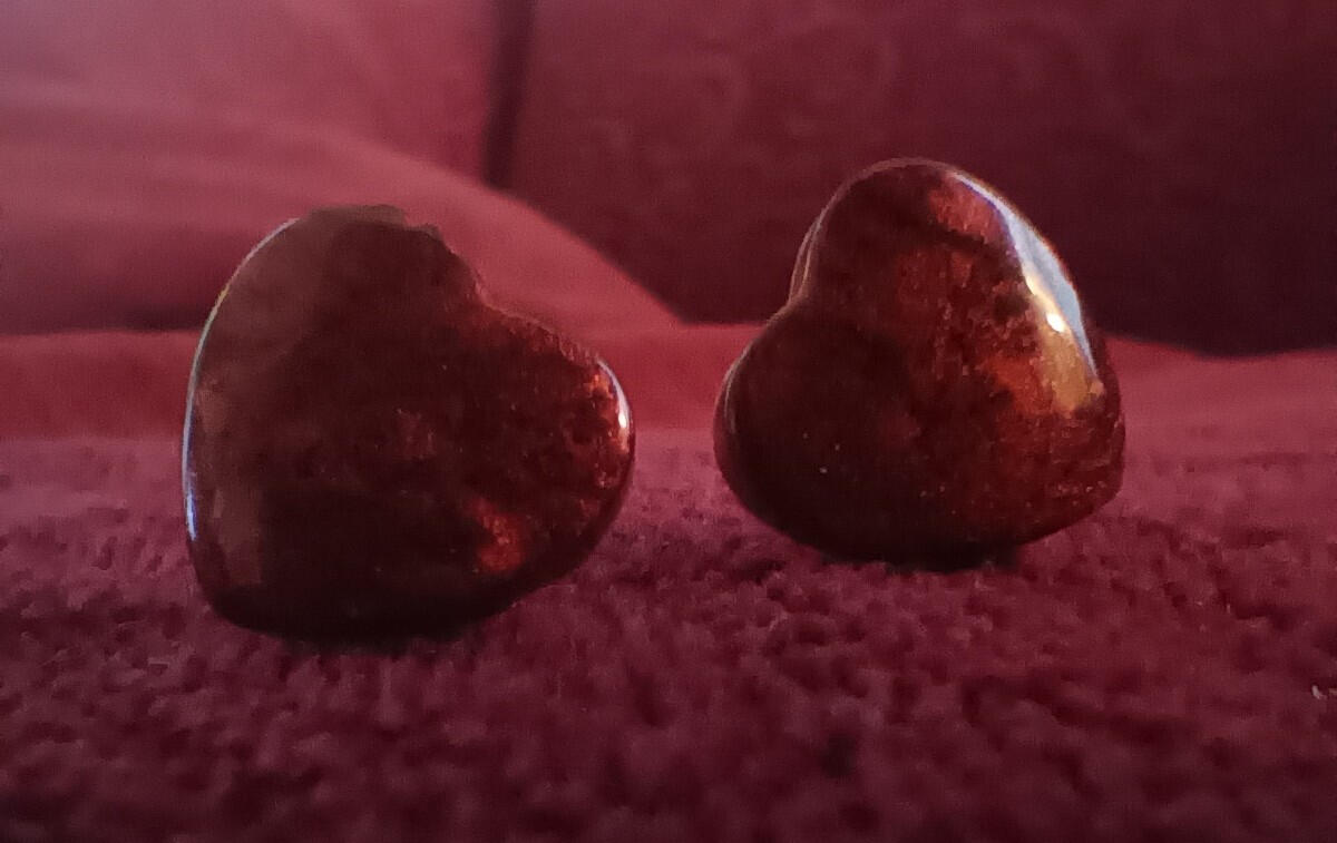 Red heart-shaped resin stud earrings colored with mica powder.