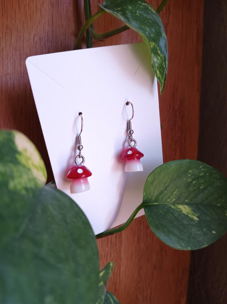 Red dangle mushroom earrings colored with mica powder and alcohol ink.